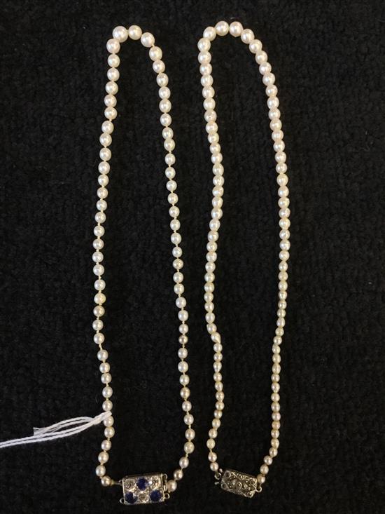 Two pearl necklaces, one with diamond and sapphire clasp